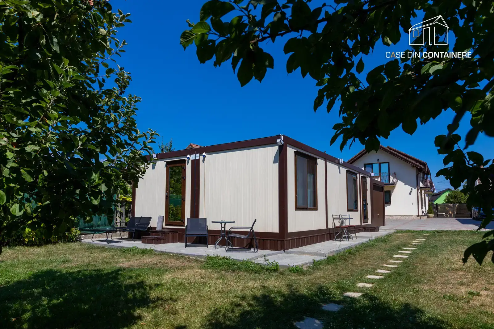 Casa din containere izolata, amplasata intr-o curte verde, exemplu de locuinta eficienta energetic si confortabila in 2025