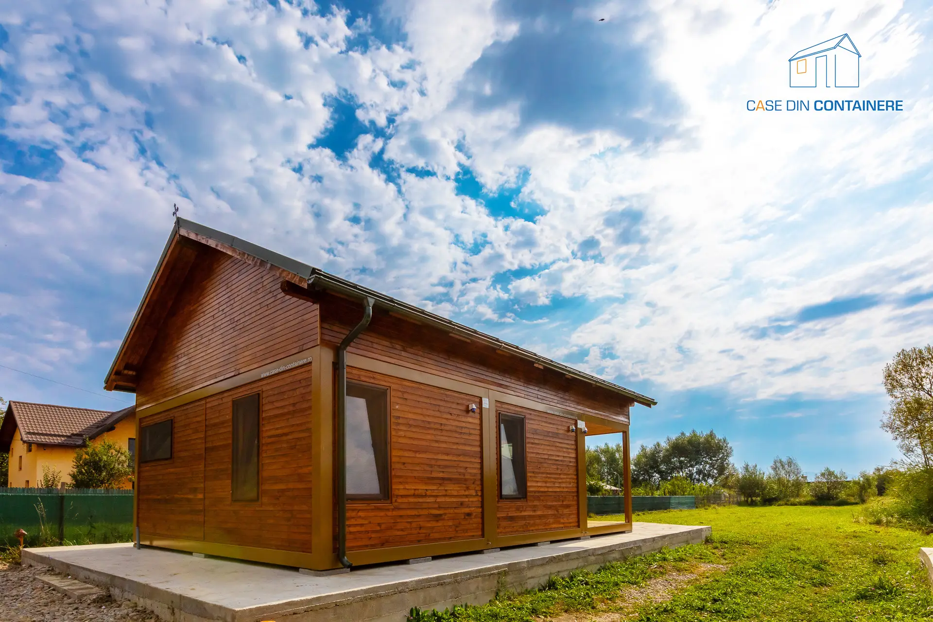 Casa moderna din containere, finisata cu lemn, construita rapid, amplasata într-un spatiu verde