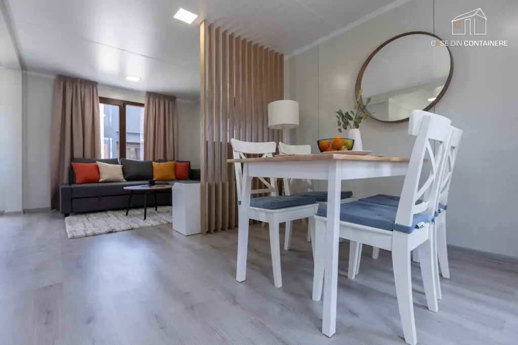 Interior modern si spatios al unei case din containere, amenajat cu zona de dining si living